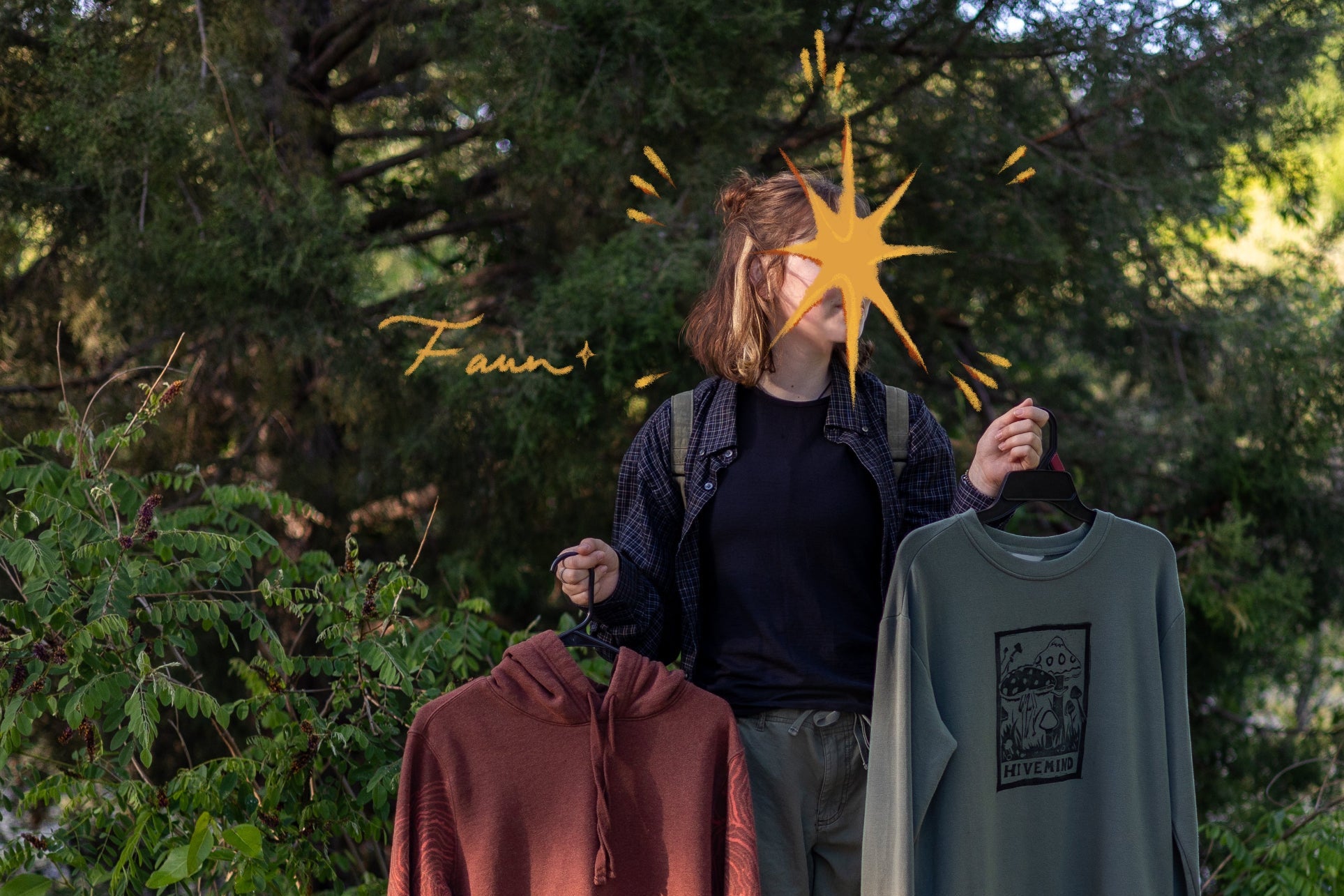 Person holding two clothing items outdoors with trees in the background